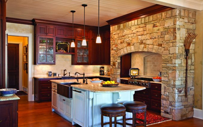 The beautiful kitchen in this Georgia lake house includes a stone hearth designed by Boston Interior Designer Elizabeth Swartz Interiors.