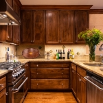 The kitchen of a Boston brownstone with interior design by Elizabeth Swartz Interiors is renovated in the traditional style with polished finishes and traditional furnishings, honoring its historic Boston roots.