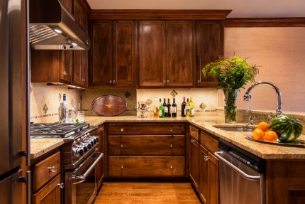 The kitchen of a Boston brownstone with interior design by Elizabeth Swartz Interiors is renovated in the traditional style with polished finishes and traditional furnishings, honoring its historic Boston roots.