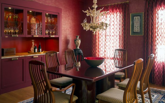 The contemporary interior design of this dining room blends rich colors, custom cabinetry, warm woods, glass and modern fabrics.