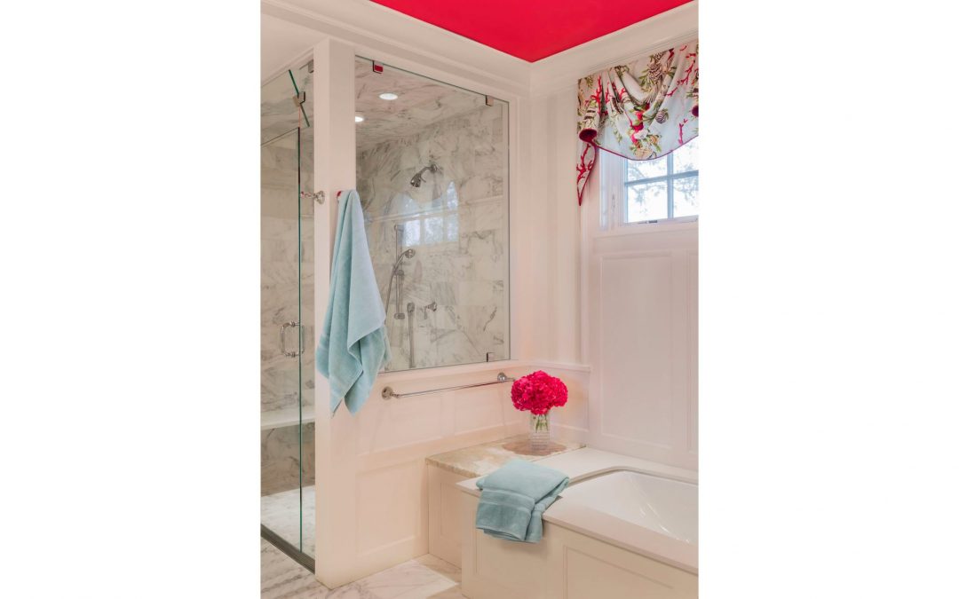 The master bath of this contemporary coastal home designed by Boston Interior Designer Elizabeth Swartz Interiors features custom window treatments that tie the bold pink ceiling to the cool blue linens.