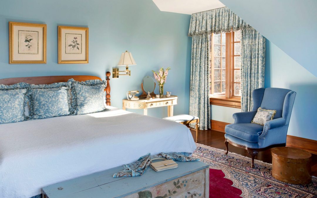 The master bedroom of this Vermont farmhouse by Boston Interior Designer Elizabeth Swartz Interiors combines contemporary design elements with traditional architectural details and custom window treatments.