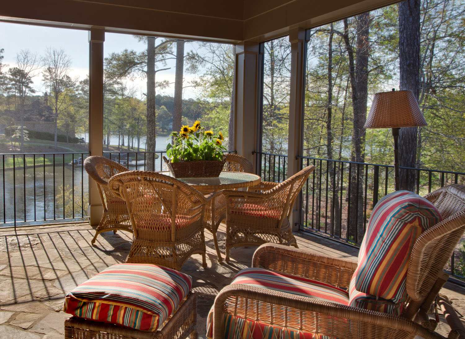 Boston interior designer Elizabeth Swartz Interiors helps to take the indoor living outdoors with the use of indoor lamps and other furnishings on this covered porch.